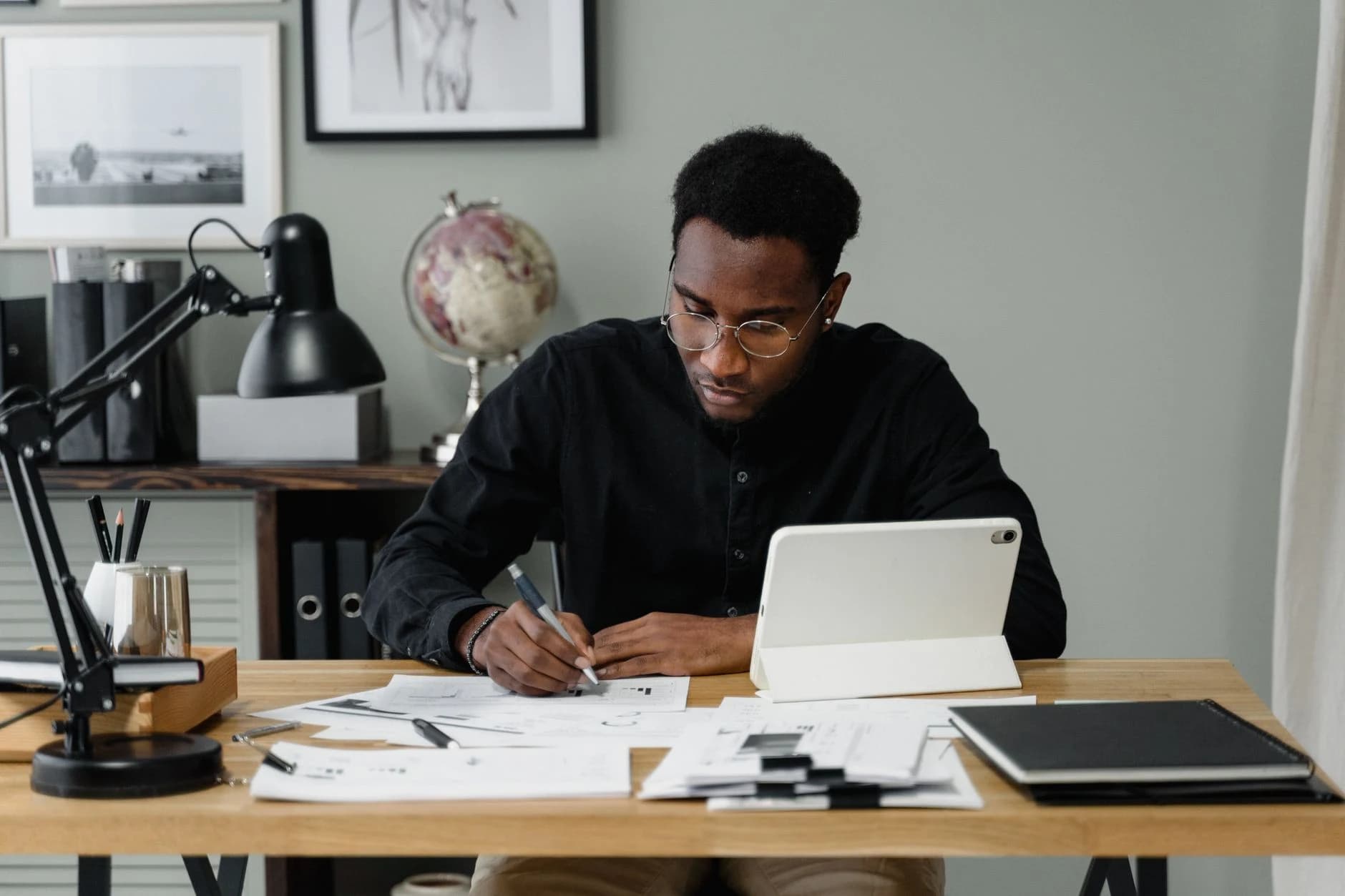 Businessman in a modern office working on documents using a digital tablet.
